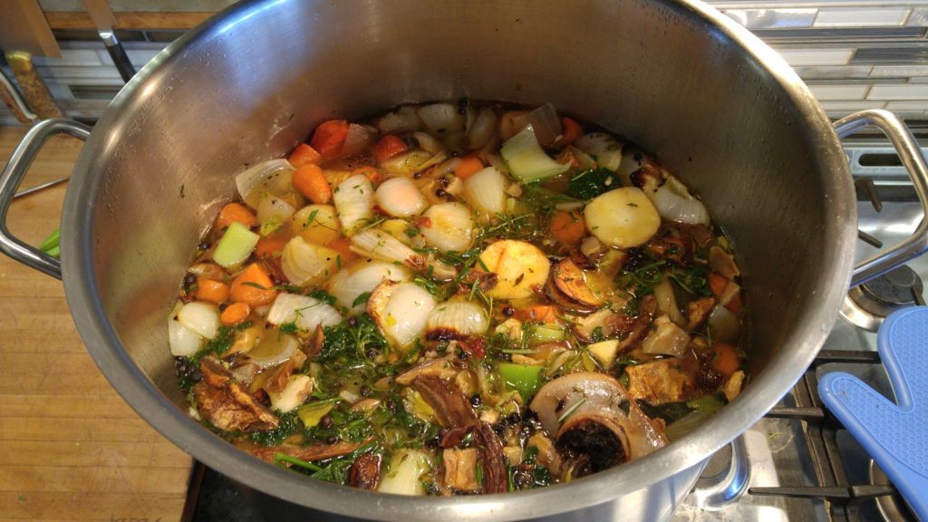 Stock pot with vegetables and herbs