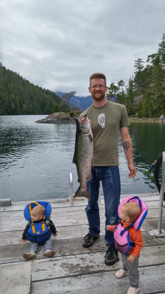 Kyle holding a salmon with Eileen and Ewan