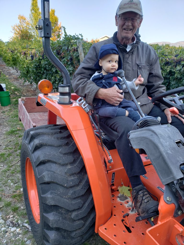 Ewan getting a ride on the tractor with Grandpa